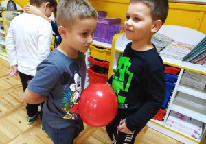 Chłopcy tańczą trzymając balon brzuchami